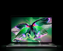 Egy kinyitott asztrofekete MacBook Pro PROLED XDR-kijelzője élénk színekkel teli, részletgazdag, nagy kontrasztú videót jelenít meg, a fénye a billentyűzetre vetül.
