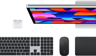 Kiegészítők és eszközök gyűjteménye, benne AirPods, Magic Keyboard Touch ID-val, Magic Mouse, Magic Trackpad, Studio Display