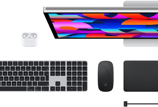 Mac-kiegészítők felülnézetből: Studio Display, AirPods, Magic Keyboard, Magic Mouse és Magic Trackpad