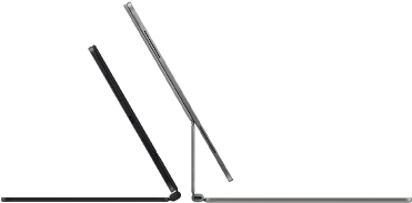 Két iPad Pro készülék Magic Keyboardhoz csatlakoztatva, oldalnézetből, vékony profillal, egy asztrofekete változat hangszórókkal és USB-C porttal, félig nyitott helyzetben megdöntve, valamint egy ezüstszínű változat, nyitott helyzetben hátradöntve, így megfigyelhető a billentyűzet konzolos lebegő dizájnja, valamint a hangszórók és a mikrofon