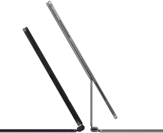 2Két iPad Pro készülék Magic Keyboardhoz csatlakoztatva, oldalnézetből, vékony profillal, egy asztrofekete változat hangszórókkal és USB-C porttal, félig nyitott helyzetben megdöntve, valamint egy ezüstszínű változat, nyitott helyzetben hátradöntve, így megfigyelhető a billentyűzet konzolos lebegő dizájnja, valamint a hangszórók és a mikrofon