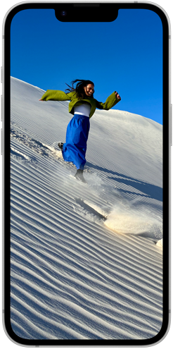 Egy homokdűnén sétáló emberek láthatók az iPhone 16e Super Retina XDR‑kijelzőjén.