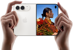 Vízszintes tájolású iPhone csillagfehér színben, két kézben tartva, kinyitva, a bal oldali panelen a 48 MP Dual Fusion hátlapi kamerák, a jobb oldali panelen egy külső kijelzőn fotózkodó ember, aki felvételkészítés közben láthatja a saját arcát a Duo Preview funkcióval.